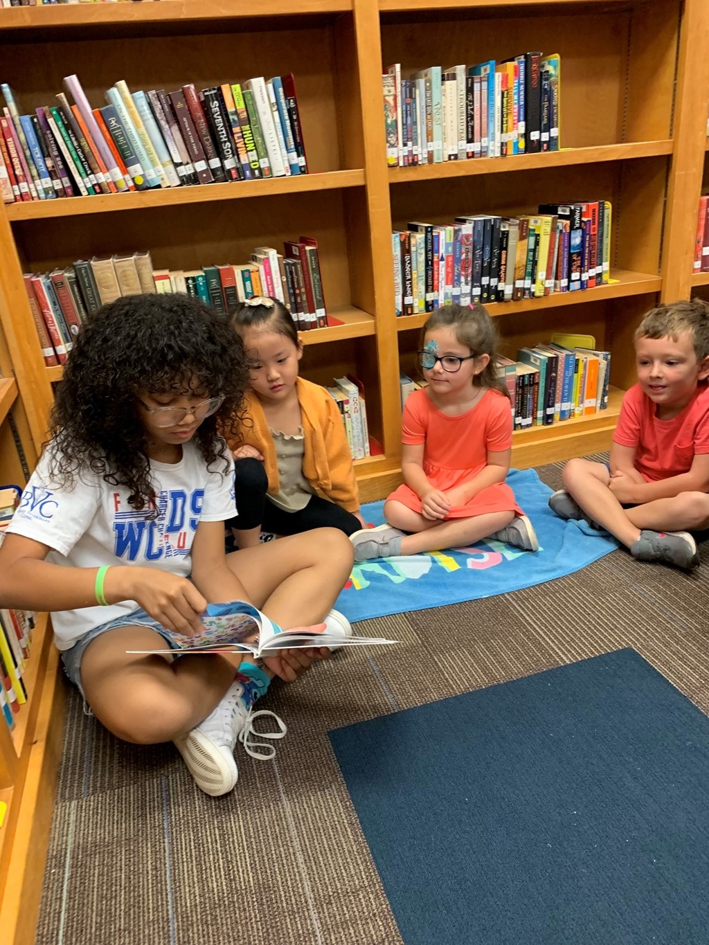 5th grade student reading to little kids