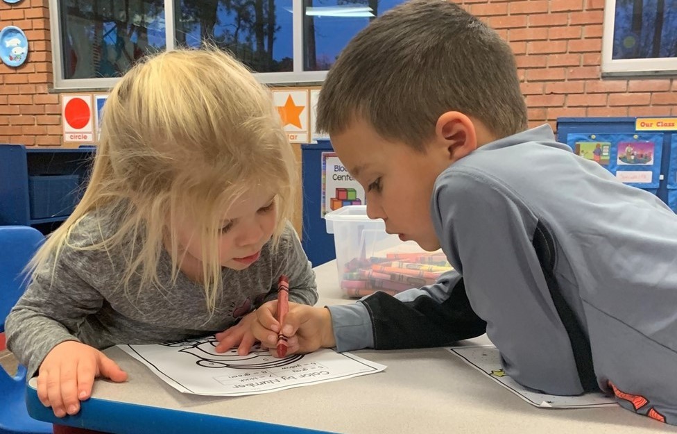 Kindergartner helping 3K student