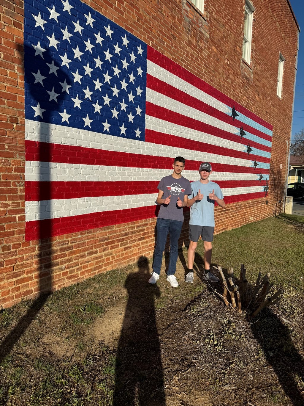 French exchange students standing next to American flag mural