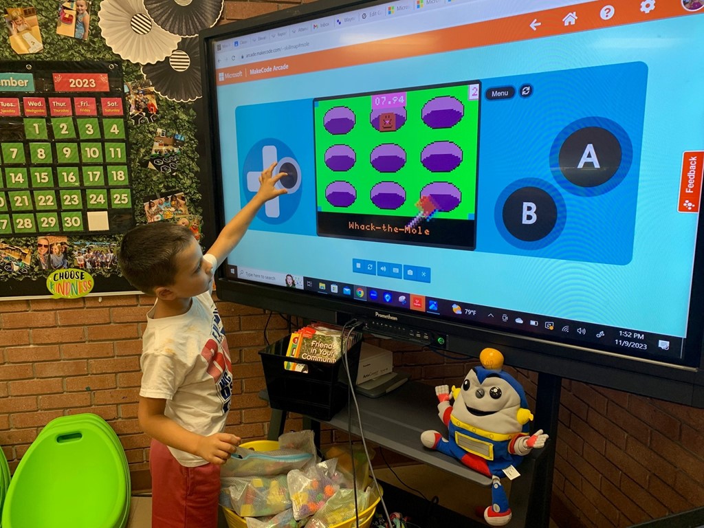 1st grade student playing with game they coded